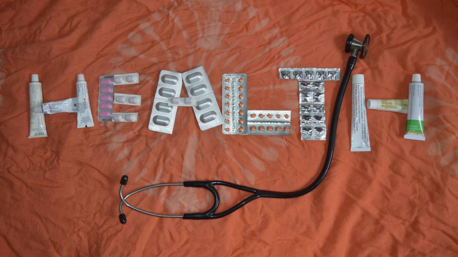health sign made with pills and lotions and a stethoscope