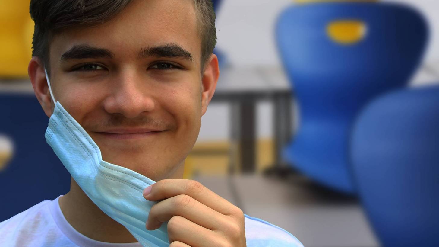 young man smiling take mask off since he is immune to SARS