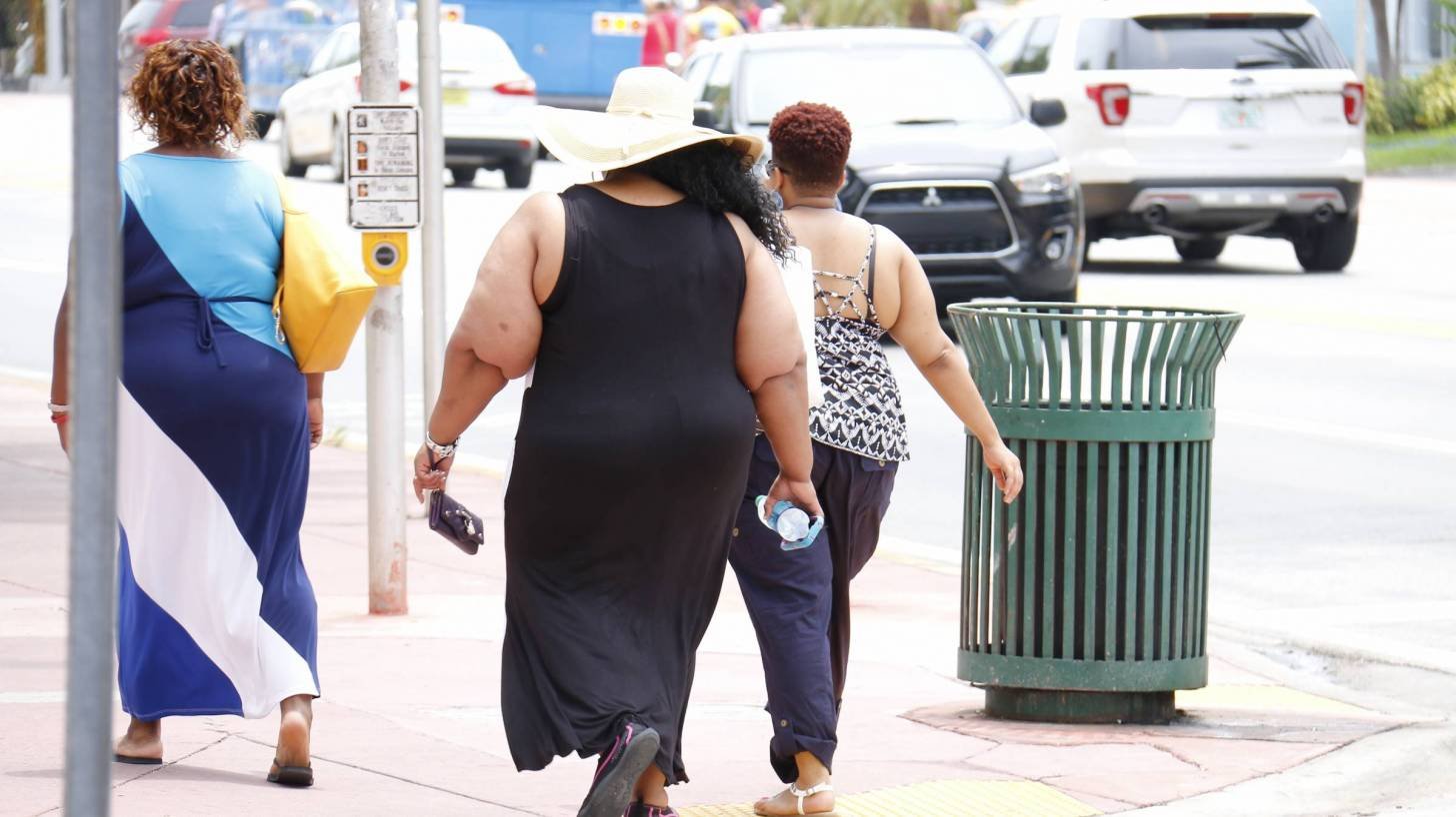 backs of obese people walking away