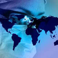 health care worker with mask on and globe under the photo