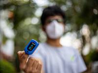 young man with a mask on taking his oxygen level